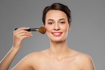 Image showing beautiful woman with makeup brush applying blusher