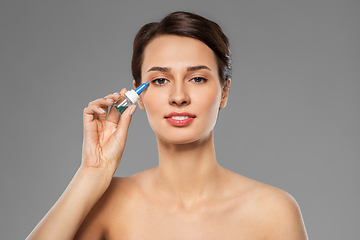 Image showing beautiful young woman with eye drops
