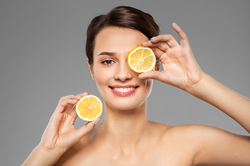 Image showing beautiful woman making eye mask of lemon slices