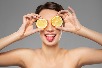 Image showing beautiful woman making eye mask of lemon slices