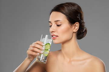 Image showing woman drinking water with cucumber and ice
