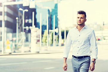 Image showing young man walking along city street