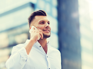 Image showing happy man with smartphone calling on city street