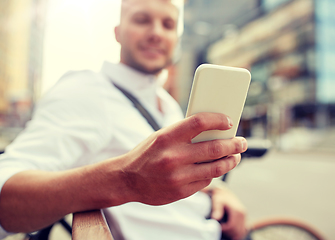 Image showing close up of man texting on smartphone in city