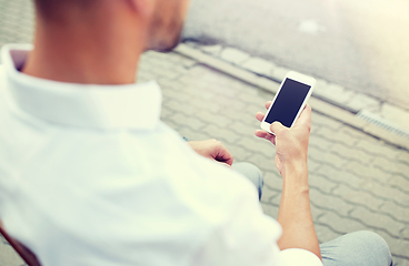 Image showing close up of man texting on smartphone in city