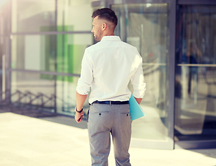 Image showing young man with folder on city street