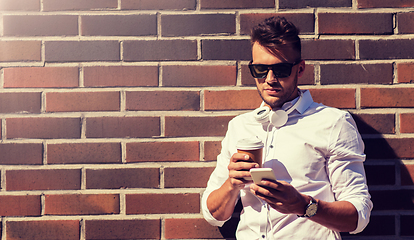 Image showing man with smartphone and coffee cup on city street