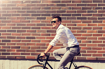 Image showing young man riding bicycle on city street