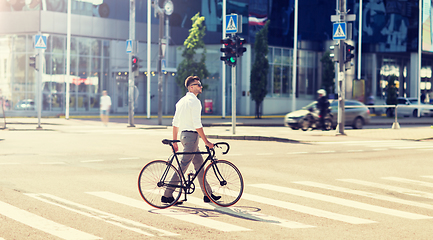 Image showing young man with bicycle on crosswalk in city