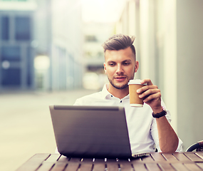 Image showing man with laptop and coffee at city cafe