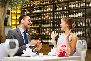 Image showing man making proposal to happy woman at restaurant