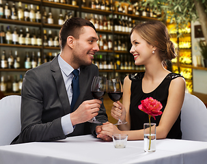 Image showing happy couple drinking red wine at restaurant