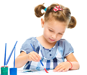 Image showing Little girl is painting with gouache