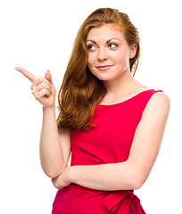 Image showing Portrait of a young woman pointing to the left