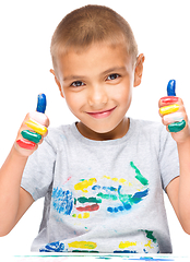 Image showing Portrait of a cute boy playing with paints