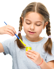 Image showing Little girl is painting with gouache