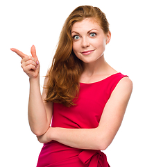 Image showing Portrait of a young woman pointing to the left