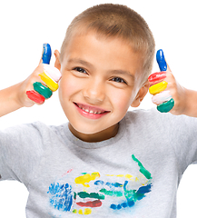 Image showing Portrait of a cute boy playing with paints