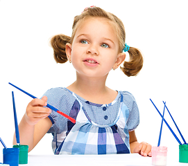 Image showing Little girl is painting with gouache