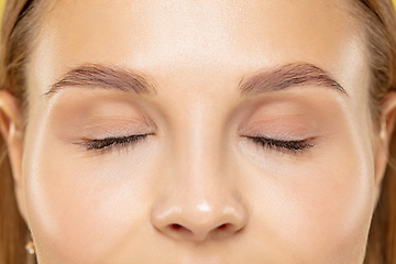 Image showing Close up shot of young woman on yellow background