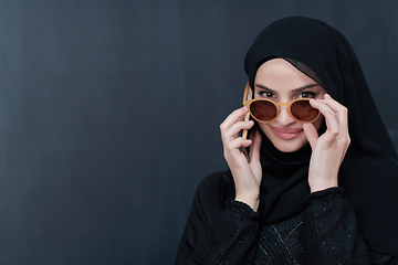 Image showing Young muslim businesswoman in traditional clothes or abaya using smartphone