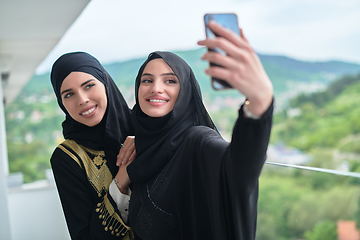 Image showing Portrait of young muslim women taking selfie on the balcony