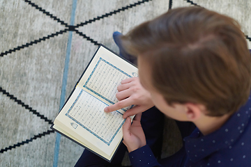 Image showing Young muslim man reading Quran during Ramadan