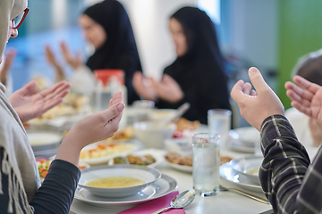 Image showing Muslim family making iftar dua to break fasting during Ramadan.