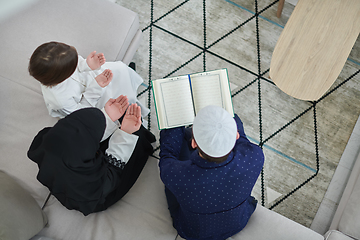 Image showing Top view of young muslim family reading Quran during Ramadan