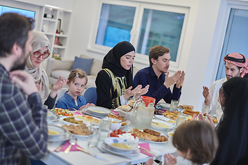 Image showing Muslim family making iftar dua to break fasting during Ramadan.