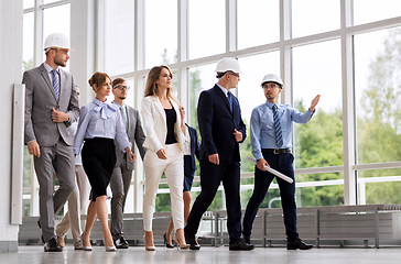 Image showing business team in helmets walking along office