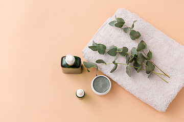 Image showing serum, clay mask, oil and eucalyptus on bath towel