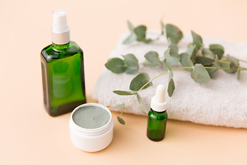 Image showing serum, clay mask, oil and eucalyptus on bath towel