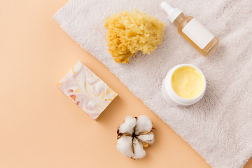 Image showing body butter, essential oil, sponge on bath towel