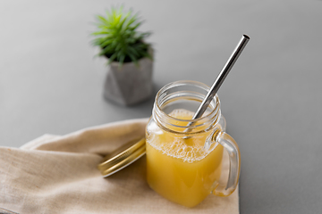 Image showing glass mug of juice and reusable metallic straw