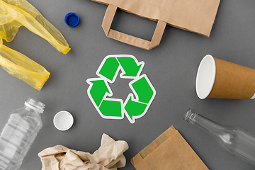 Image showing green recycle symbol with household waste on grey