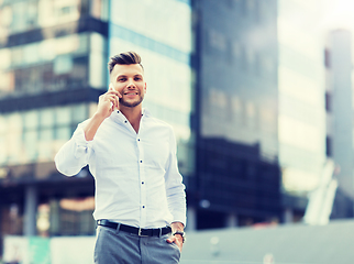 Image showing happy man with smartphone calling on city street