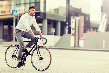 Image showing man with headphones riding bicycle on city street