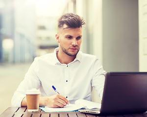 Image showing man with laptop and coffee at city cafe