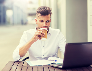 Image showing man with laptop and coffee at city cafe