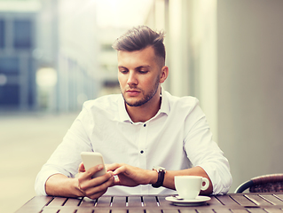 Image showing man with smartphone and coffee at city cafe