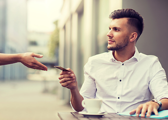 Image showing man with credit card paying for coffee at cafe