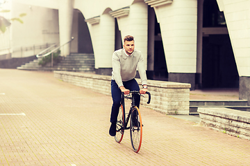 Image showing young man riding bicycle on city street