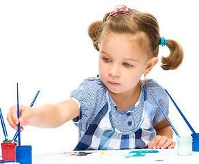 Image showing Little girl is painting with gouache