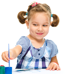 Image showing Little girl is painting with gouache