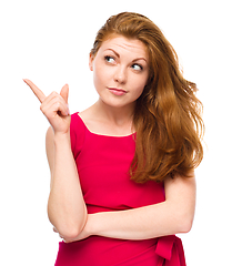 Image showing Portrait of a young woman pointing to the left