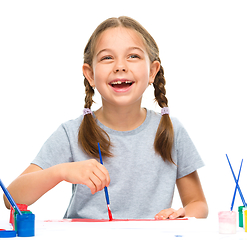 Image showing Little girl is painting with gouache