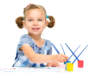 Image showing Little girl is painting with gouache