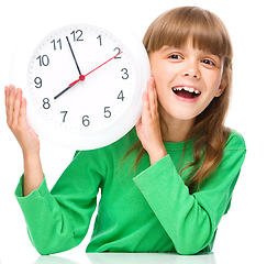 Image showing Little girl is holding big clock