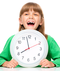 Image showing Little girl is holding big clock